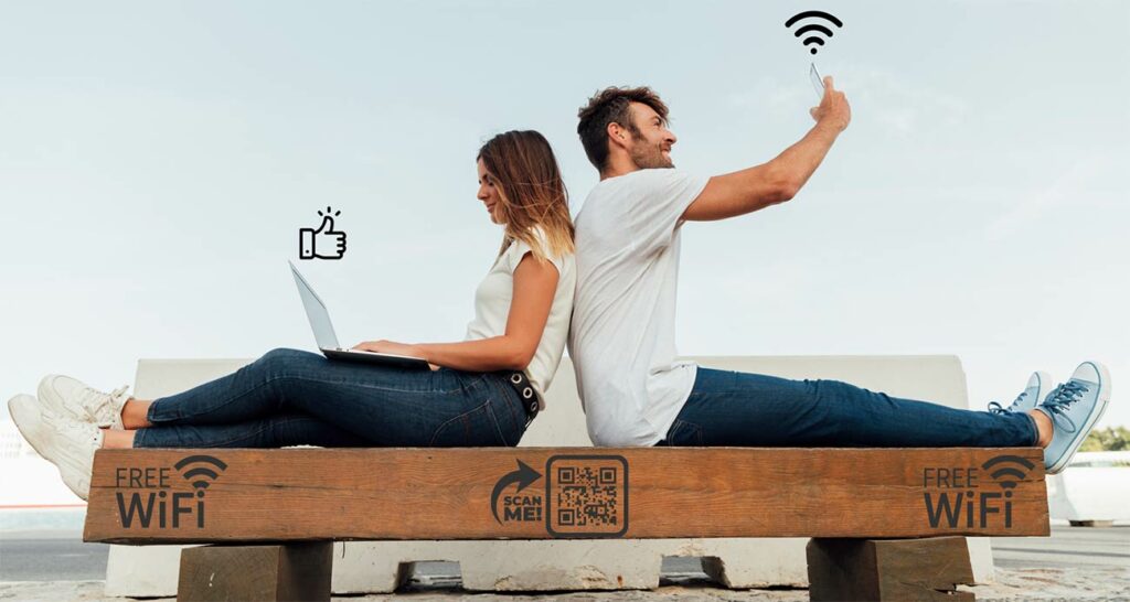 Pareja sentada en un banco en un lugar público usando Wi-Fi
