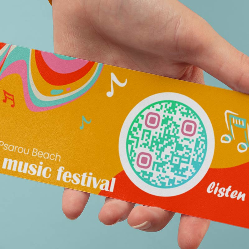 Una mano sujetando un folleto de un festival de música con un código QR de audio que lleva a una demostración