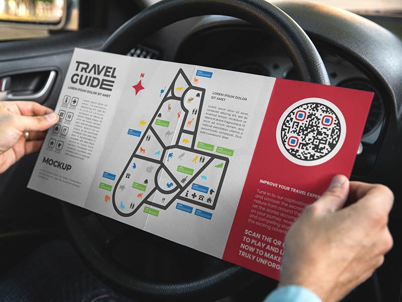 Código QR en guía de viajes abierta por una persona que va en coche