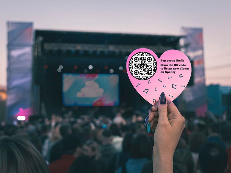 Spotify QR-koodiga brošüür kontserdil tüdruku käes