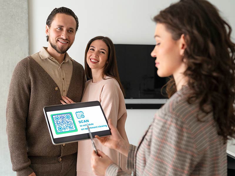 Agente inmobiliario mostrando la casa y ofreciendo a la gente que escanee el código QR del evento para ver otra propiedad